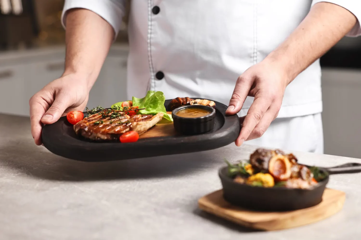 Professional chef serving dish at table indoors, closeup